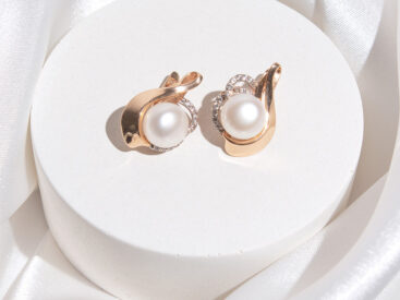orecchini in oro, diamanti e perle su fondo bianco con stola in seta